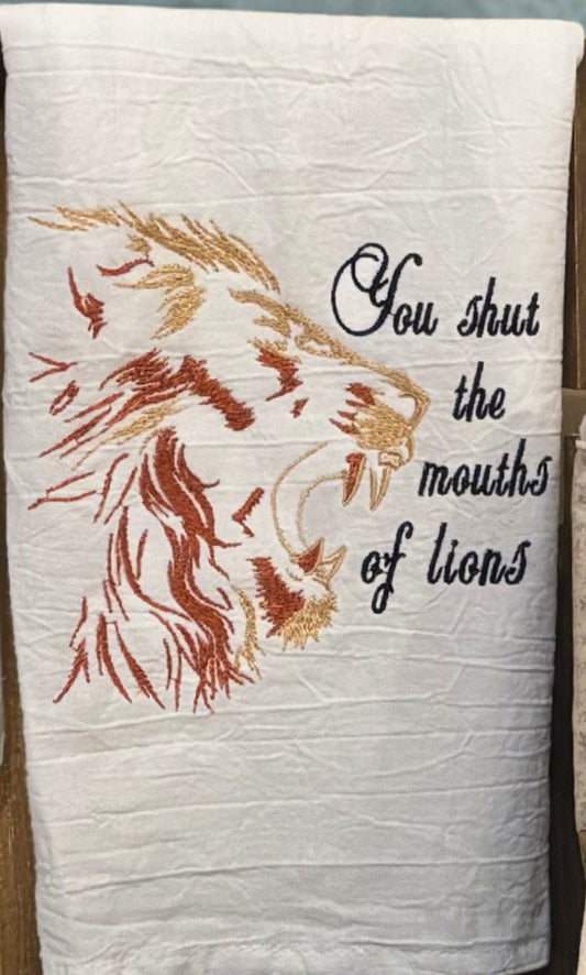 Towel with lion design and text 'You shut the mouths of lions' on a white background